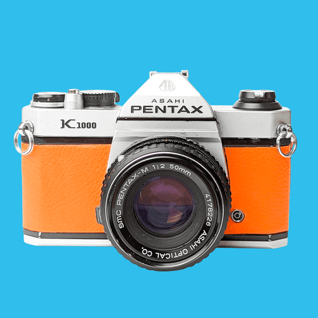 Pentax K1000 Orange Leather Vintage SLR 35mm Film Camera with Pentax f/2 50mm Prime Lens.