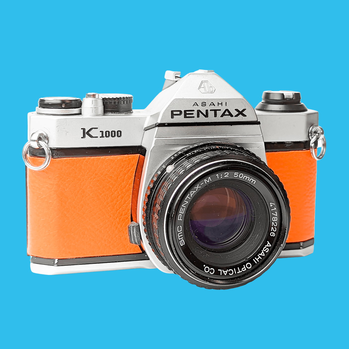 Pentax K1000 Orange Leather Vintage SLR 35mm Film Camera with Pentax f/2 50mm Prime Lens.
