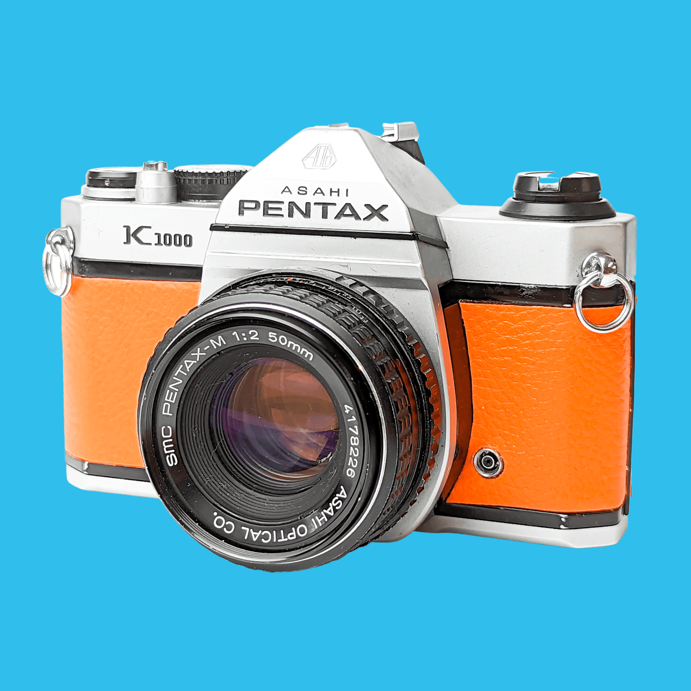 Pentax K1000 Orange Leather Vintage SLR 35mm Film Camera with Pentax f/2 50mm Prime Lens.