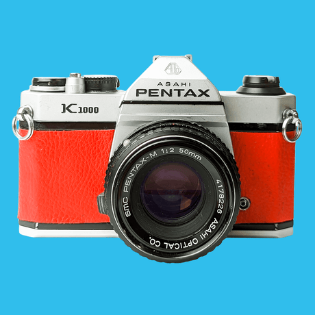 Pentax K1000 Red Leather Vintage SLR 35mm Film Camera with Pentax f/2 50mm Prime Lens.