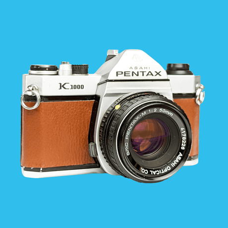 Pentax K1000 Brown Leather Vintage SLR 35mm Film Camera with Pentax f/2 50mm Prime Lens.