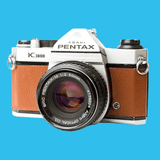 Pentax K1000 Brown Leather Vintage SLR 35mm Film Camera with Pentax f/2 50mm Prime Lens.