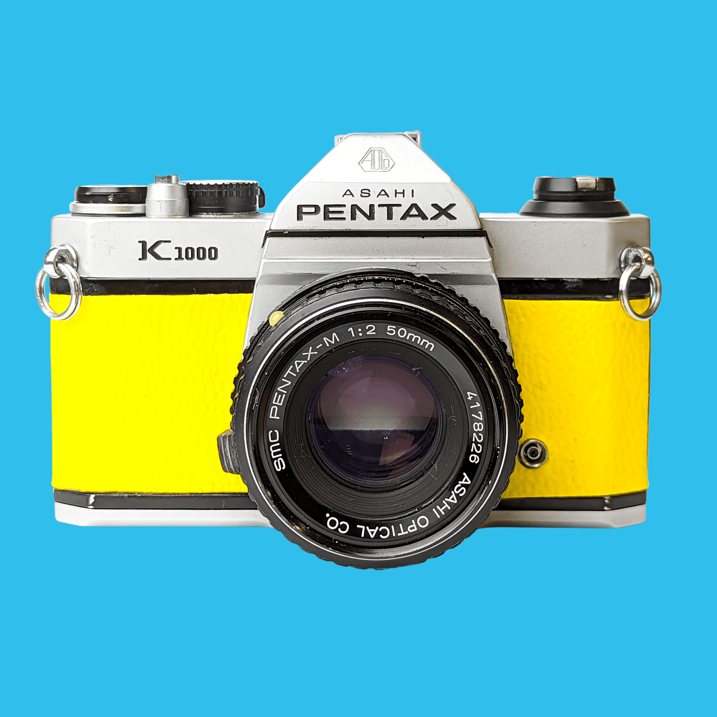 Pentax K1000 Yellow Leather Vintage SLR 35mm Film Camera with Pentax f/2 50mm Prime Lens.