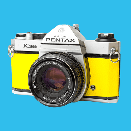 Pentax K1000 Yellow Leather Vintage SLR 35mm Film Camera with Pentax f/2 50mm Prime Lens.